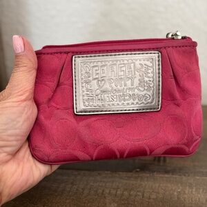 Pink Coach Wristlet with silver label on front.